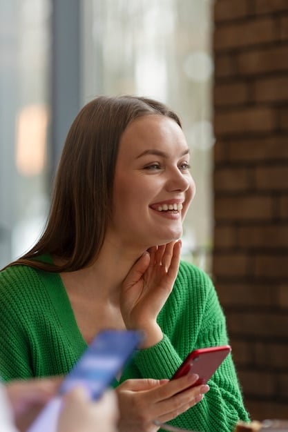 A close-up shot of a customer's face, smiling and engaged while interacting with an e-commerce website on a tablet. The screen displays personalized product recommendations and customer reviews, highlighting the seamless and enjoyable shopping experience. The background is blurred to emphasize the customer's focus and satisfaction.
