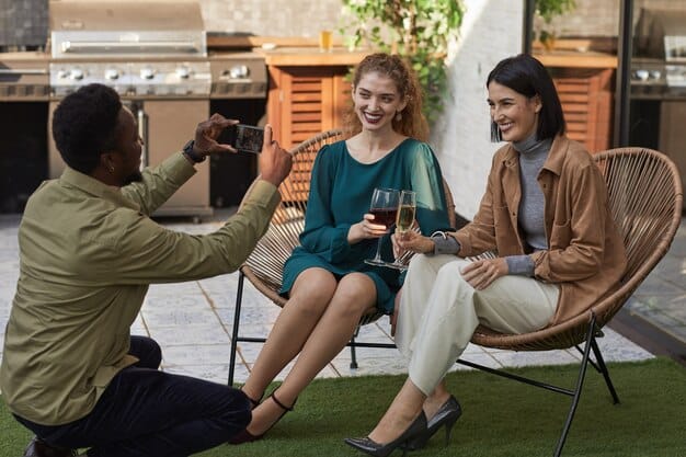 Three diverse individuals sitting in a casual setting, smiling and engaged in a conversation, representing a customer testimonial video shoot.