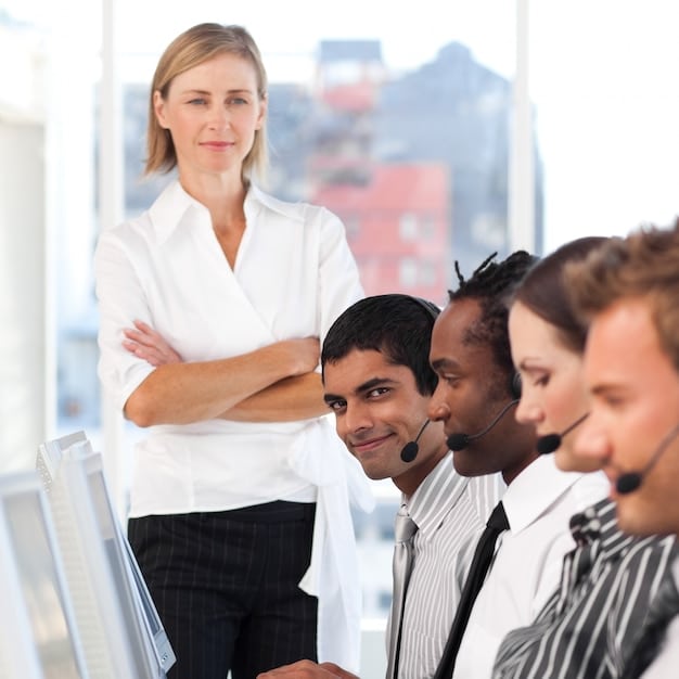 A customer service trainer is facilitating a workshop with a group of employees. The employees are actively participating in a role-playing exercise, with one employee acting as the customer and another as the service representative. The trainer is observing and providing guidance, and the atmosphere is positive and collaborative.
