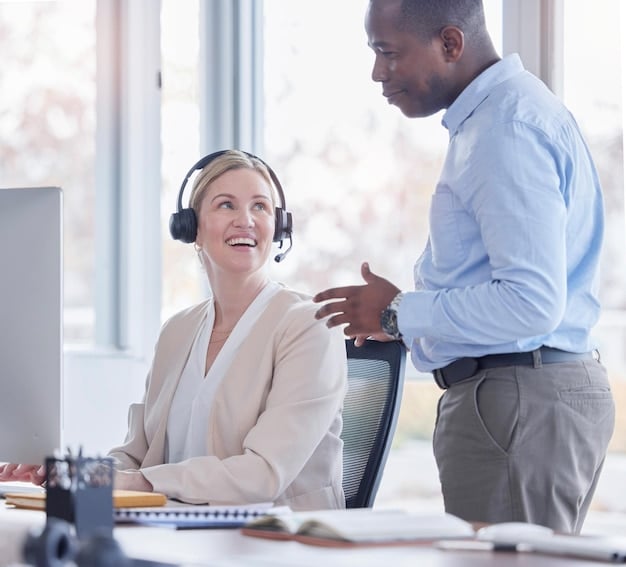 A customer service agent wearing a headset helps a business owner with setting up an E-commerce store during E-commerce Platform Support: What to Expect and How to Get the Best Service in the US in this bright office environment.
