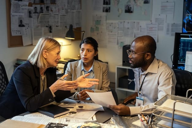 A diverse group of business professionals collaborating around a table, analyzing security reports and digital charts on a laptop, symbolizing strategic planning for security updates.