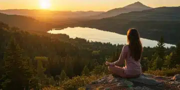 Woman meditating at sunrise on mountain, embracing wellness travel